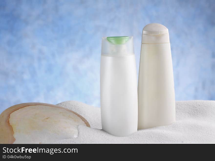 A group of beauty hygiene container with shell and dune on sky blue background