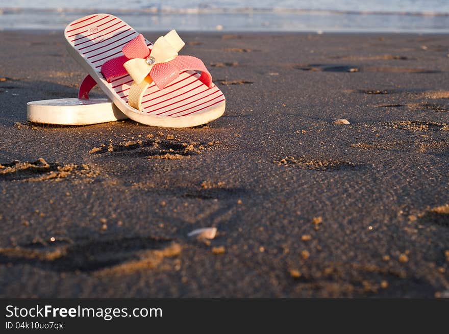 Flip-flops on the beach at sunset