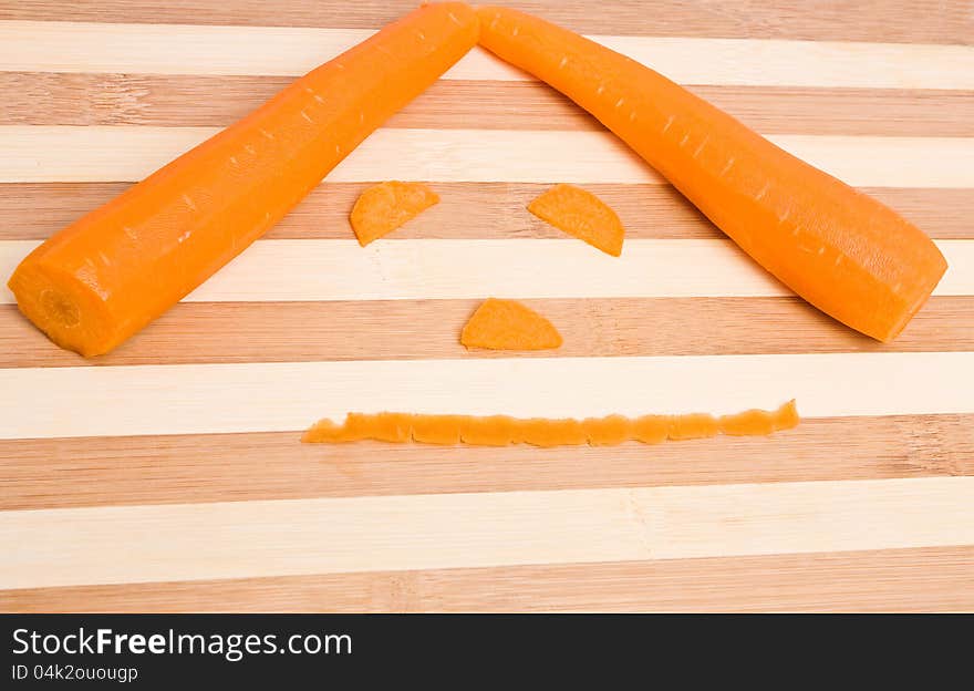 Fresh orange carrots as a face on the kitchen board. Fresh orange carrots as a face on the kitchen board.