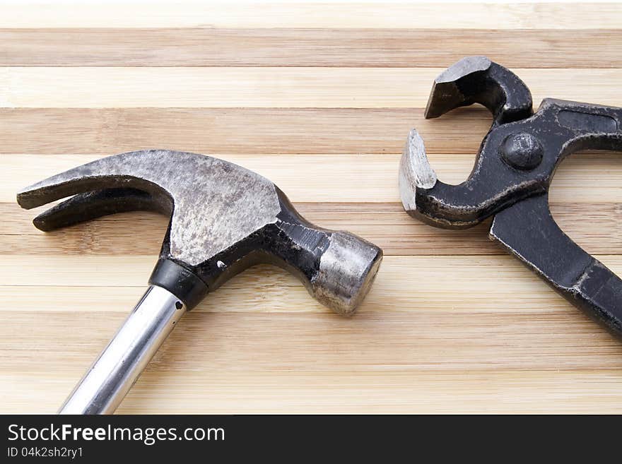 Old wrench and hammer closeup on wood background