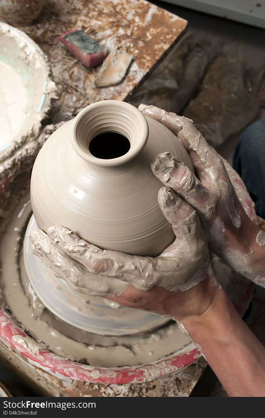 Hands of a potter, creating an earthen jar