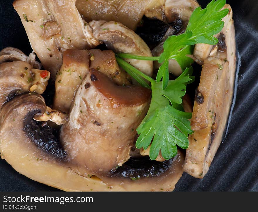 Stack of Cooked Mushrooms with Parsley on black plate