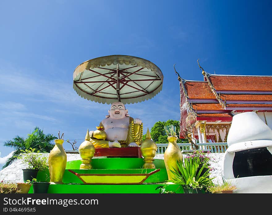 The smile buddha in Thai temple with blue sky, Rayong, Thailand. The smile buddha in Thai temple with blue sky, Rayong, Thailand