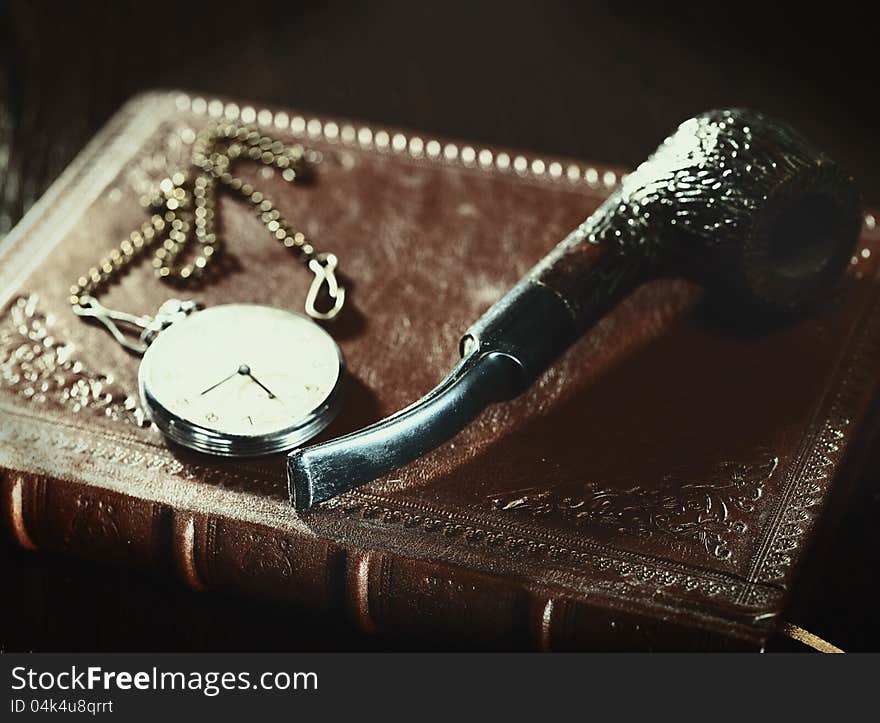 Abstract retro still life with old leather covered book and watch