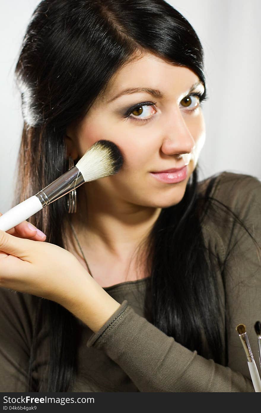 Portrait of beautiful young adult woman applying cosmetic. Portrait of beautiful young adult woman applying cosmetic