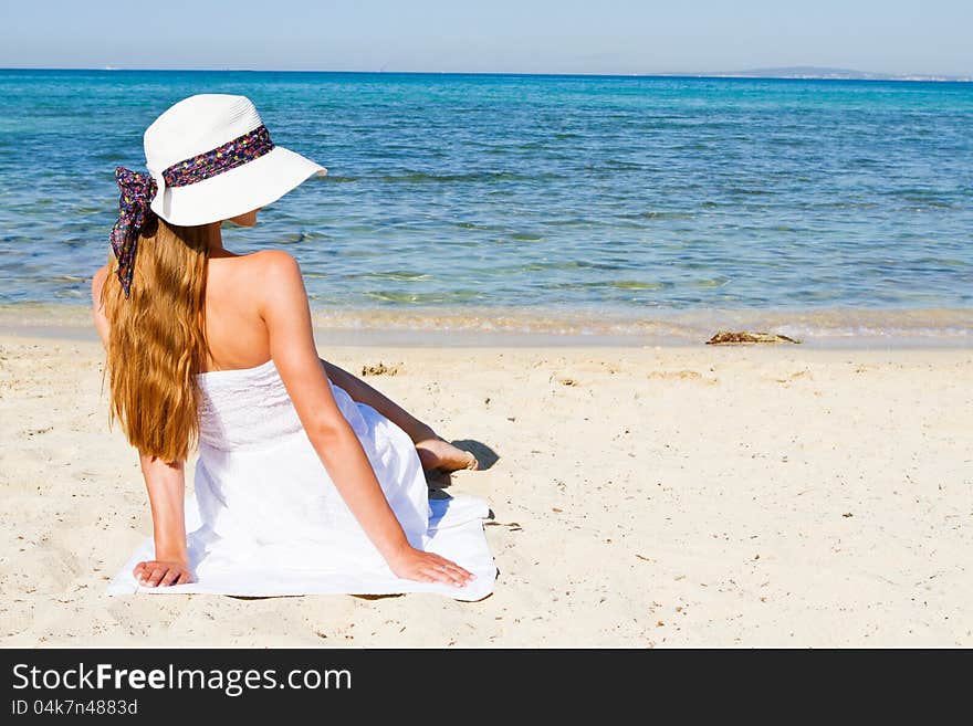 Young woman sitting on the beach