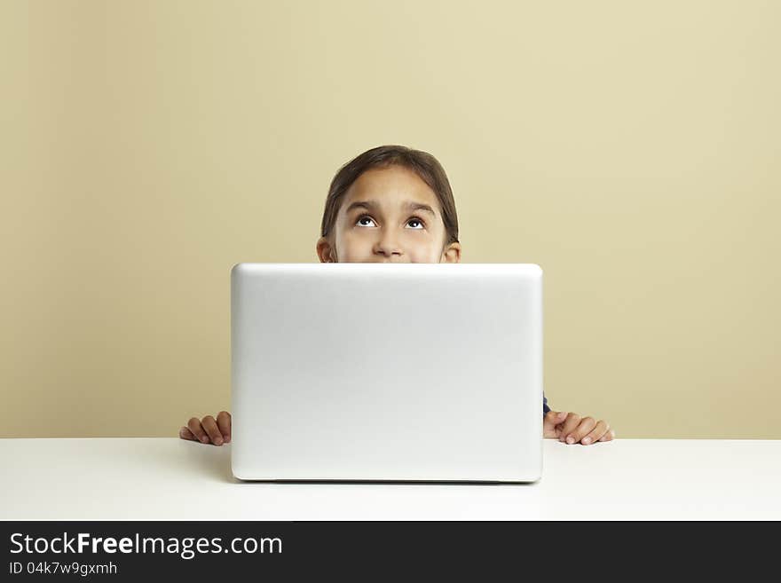 Young girl using laptop on white desk