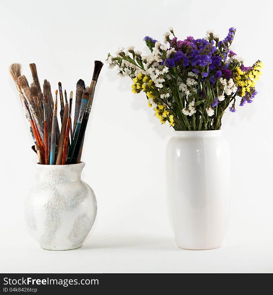 Jug with brushes and vase of wild flowers