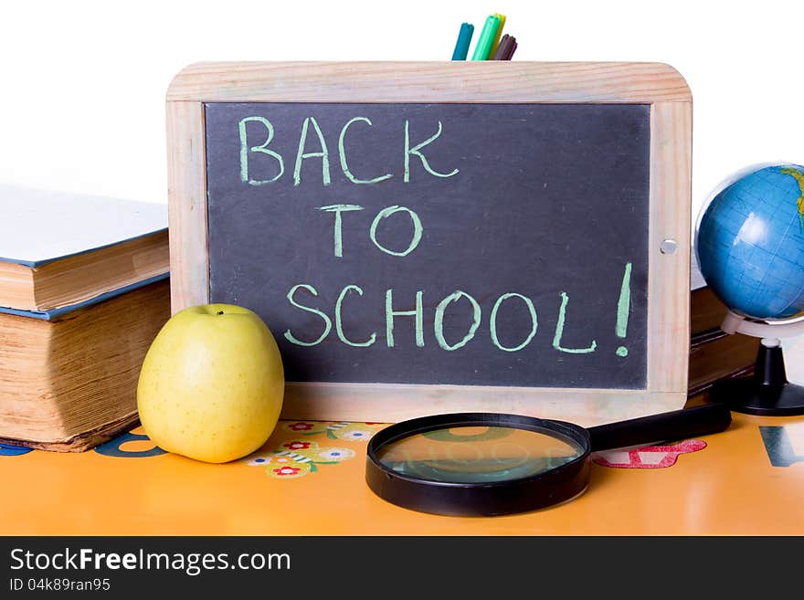 Back to school word on board, books and globe on student table