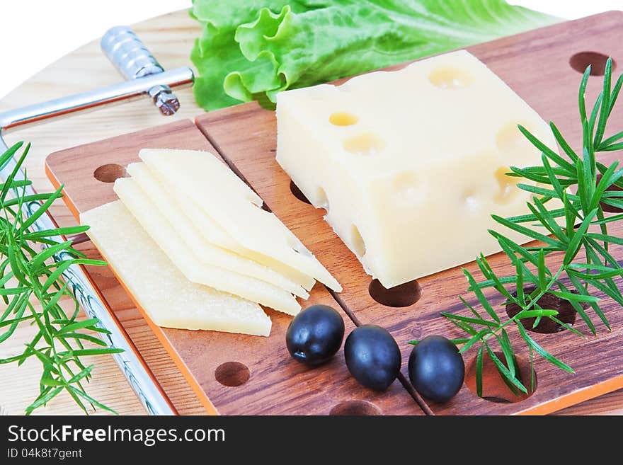 The composition of cheese, lettuce and olives. Board for cutting cheese.