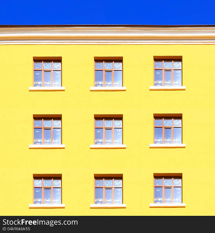 Yellow wall with windows and blue sky