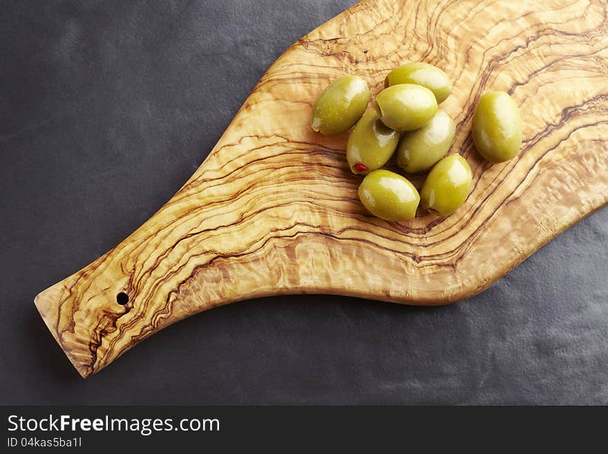 Green olives on olive wood platter