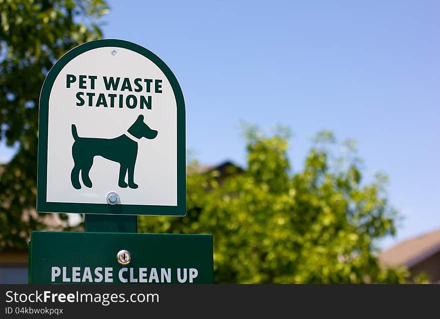 A pet waste station sign in a community park.