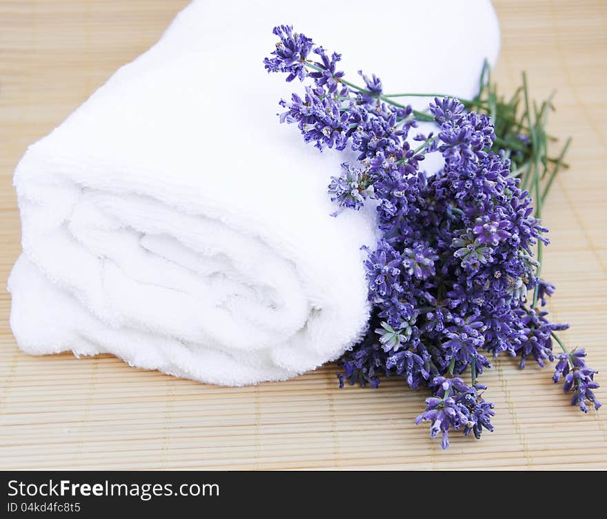 Lavender bunch with  white towel on a bamboo rug. Lavender bunch with  white towel on a bamboo rug