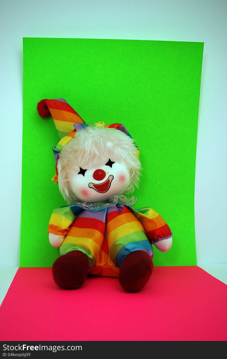 Rainbow Colored Happy Smiling Clown Doll on Bright green, red and blue Background. Rainbow Colored Happy Smiling Clown Doll on Bright green, red and blue Background