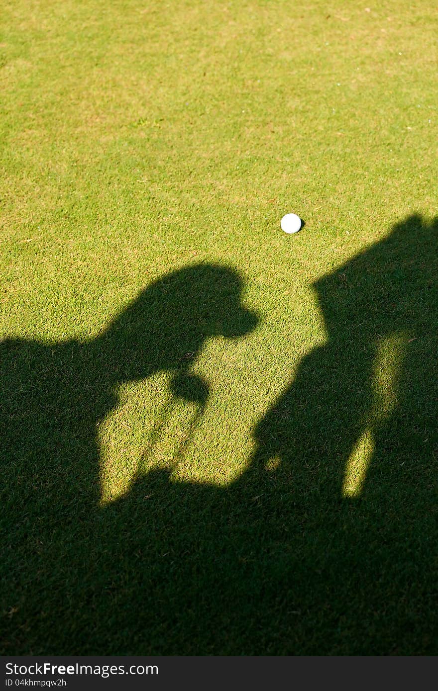 Silhouette of a golfer putting his golf clubs back in this bag in the golf cart