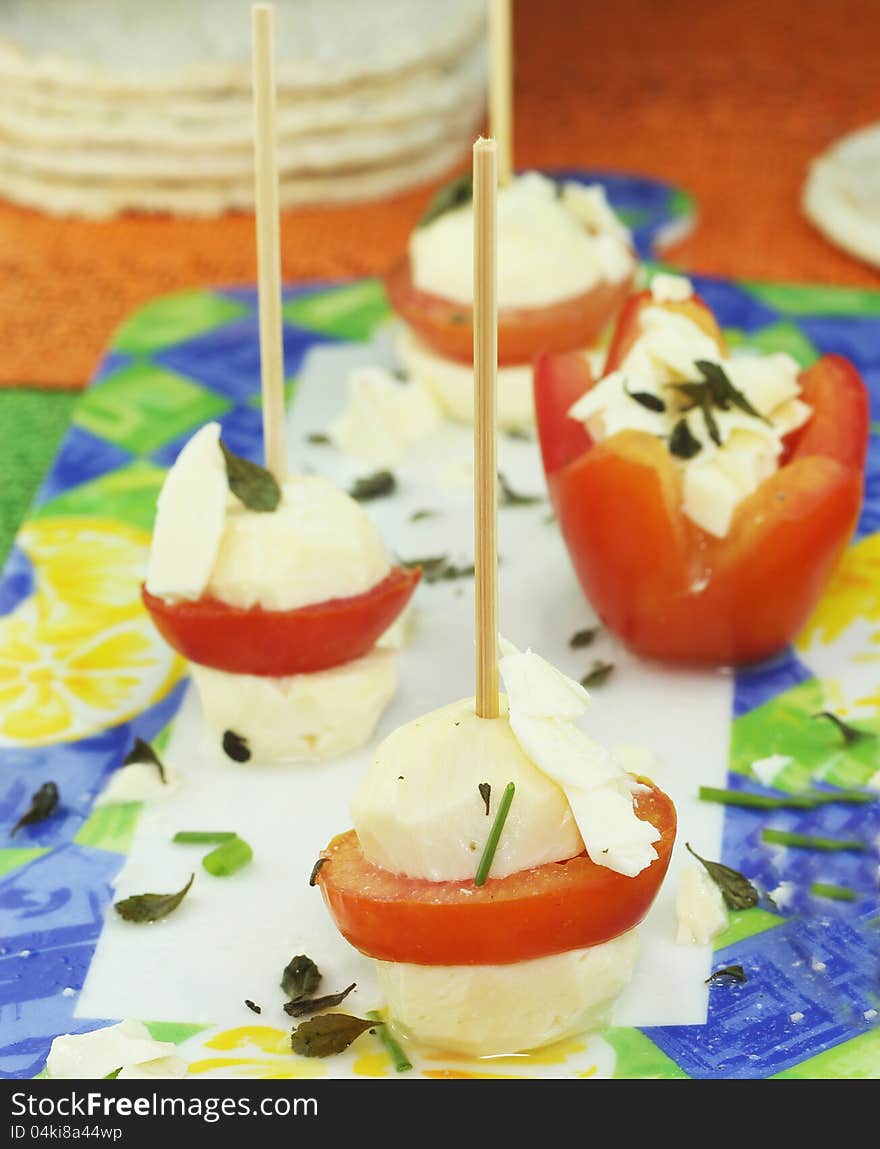 Cheese skewers with tomatoes seasoned with olive oil and oregano leaves