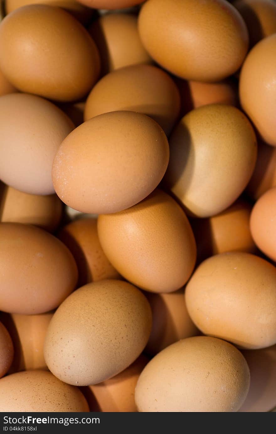 Many brown chicken eggs with light from the left side. Many brown chicken eggs with light from the left side