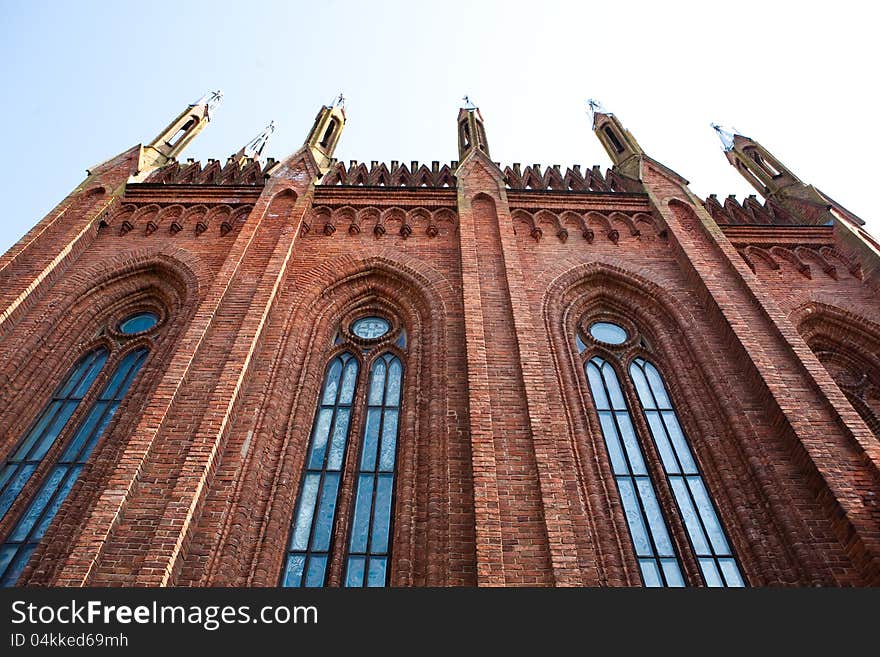 The wall of the church of red brick with a spire