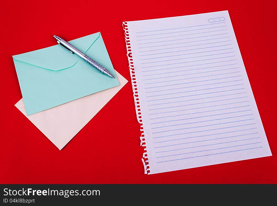 Envelope of correspondence, pen and blank notebook sheet