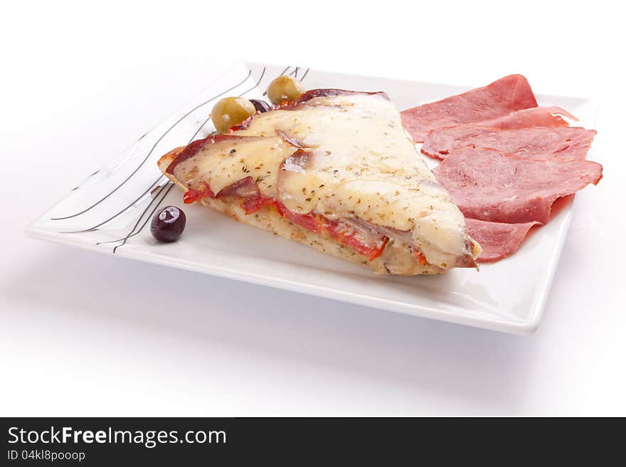 Pizza slice with olive and salami on a plate on white