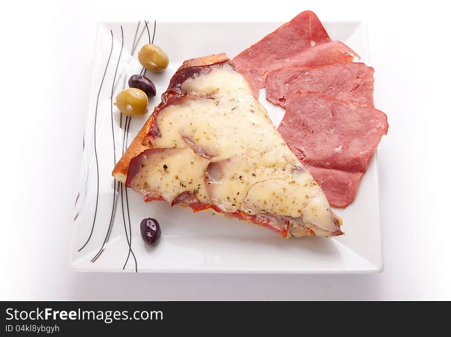 Pizza slice with olive and salami on a plate on white