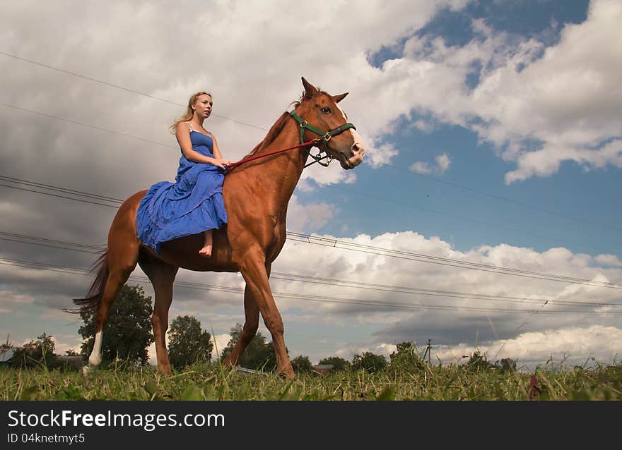 Young woman in blue dress on horseback. Young woman in blue dress on horseback