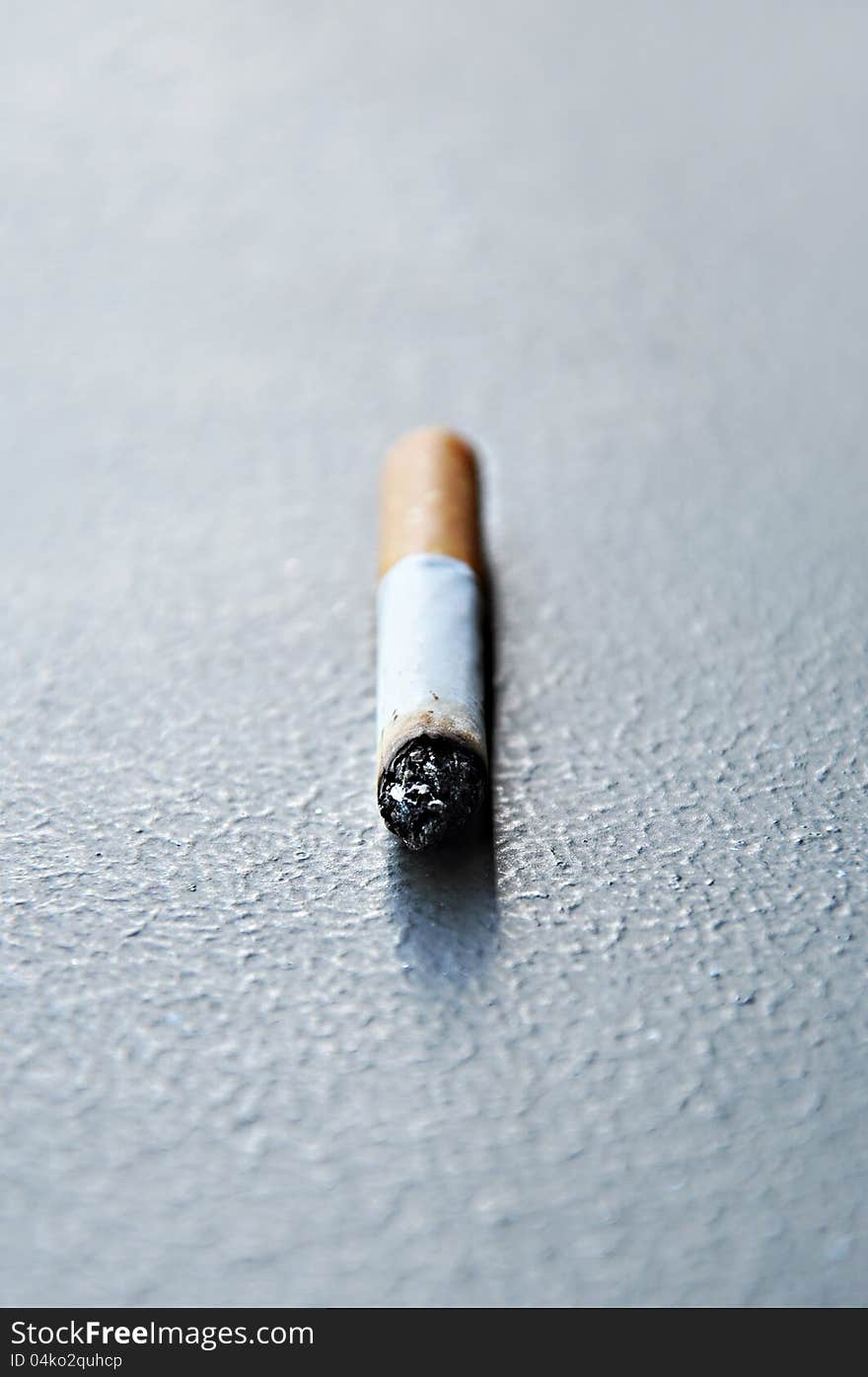 Close up of cigarette stub on the ground. Close up of cigarette stub on the ground