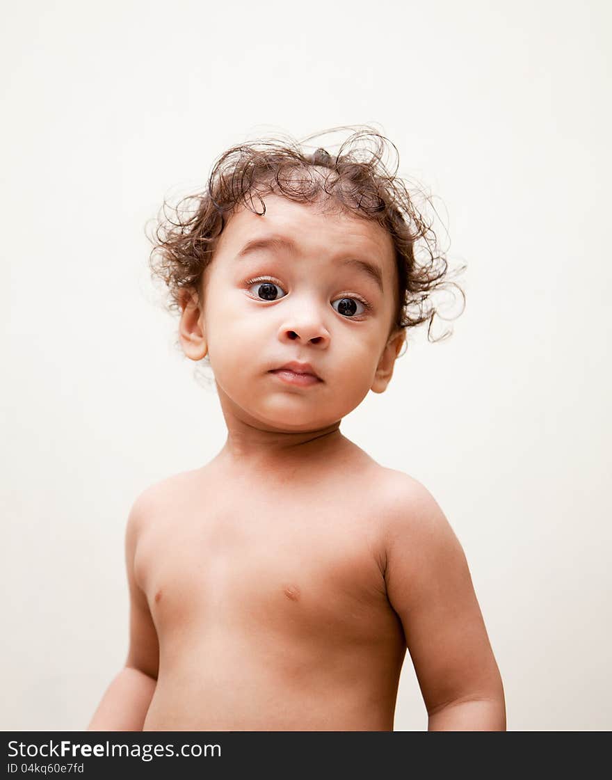 Surprised indian baby boy over white background