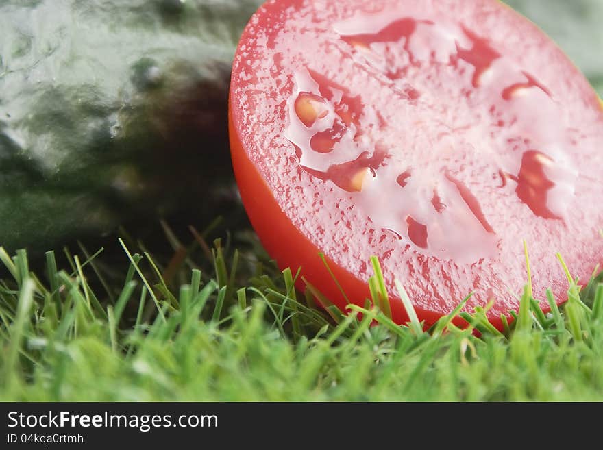 Close up of half a tomato with cucumber at the bottom