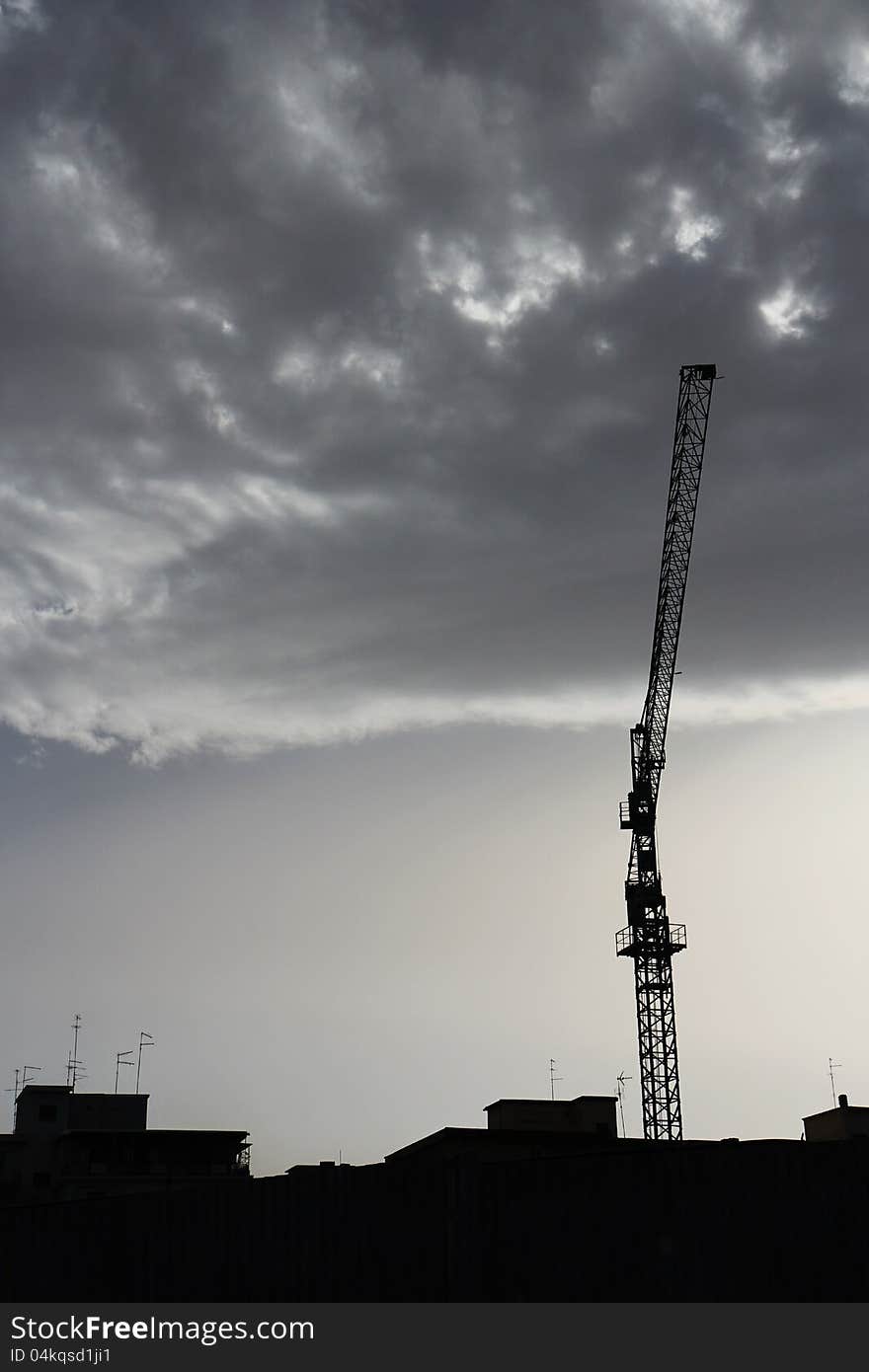 Crane silhouette over a dramatic sky with clouds