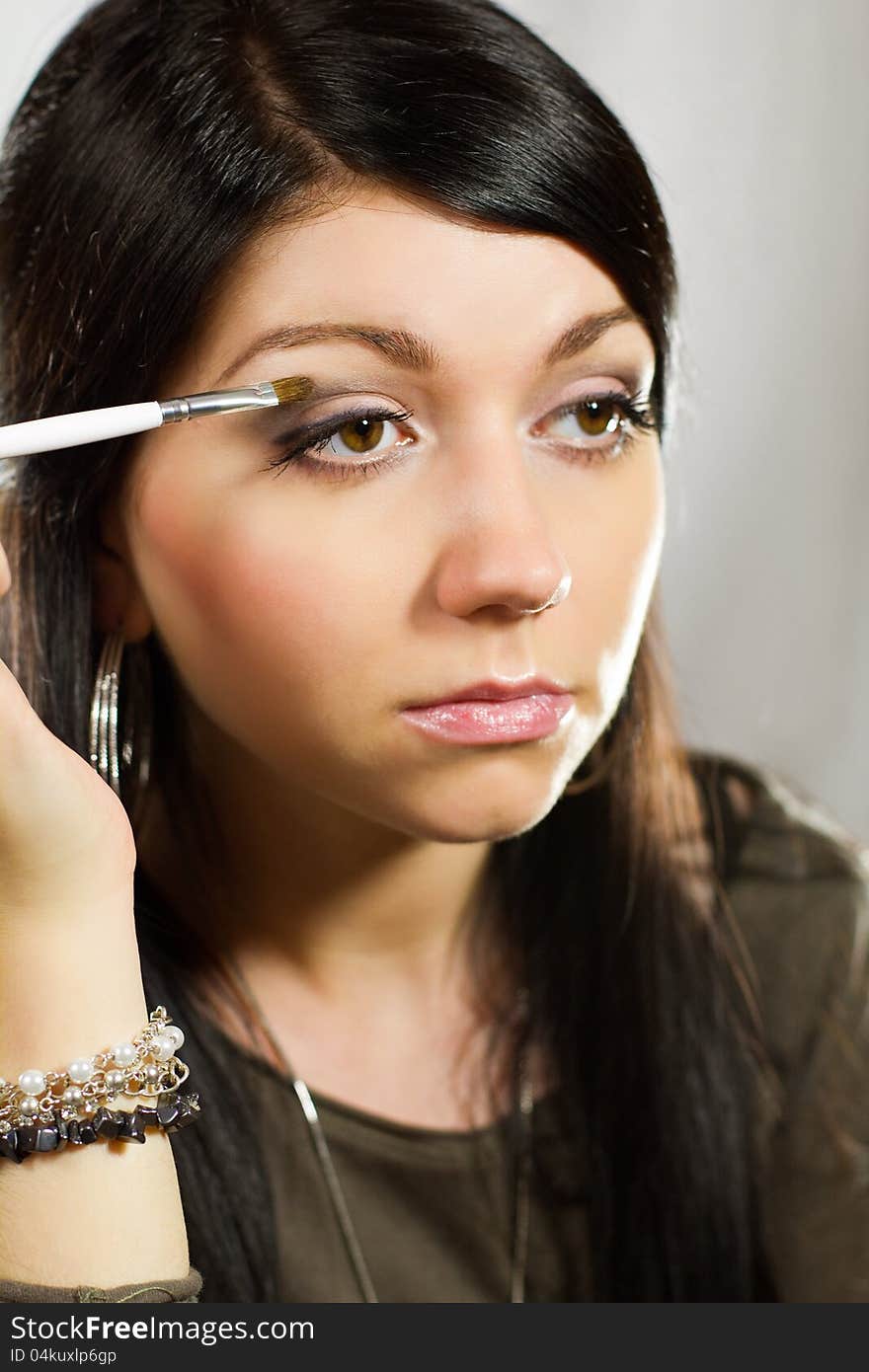 Portrait of beauty young caucasian woman applying eyeshadow on eyelid. Portrait of beauty young caucasian woman applying eyeshadow on eyelid