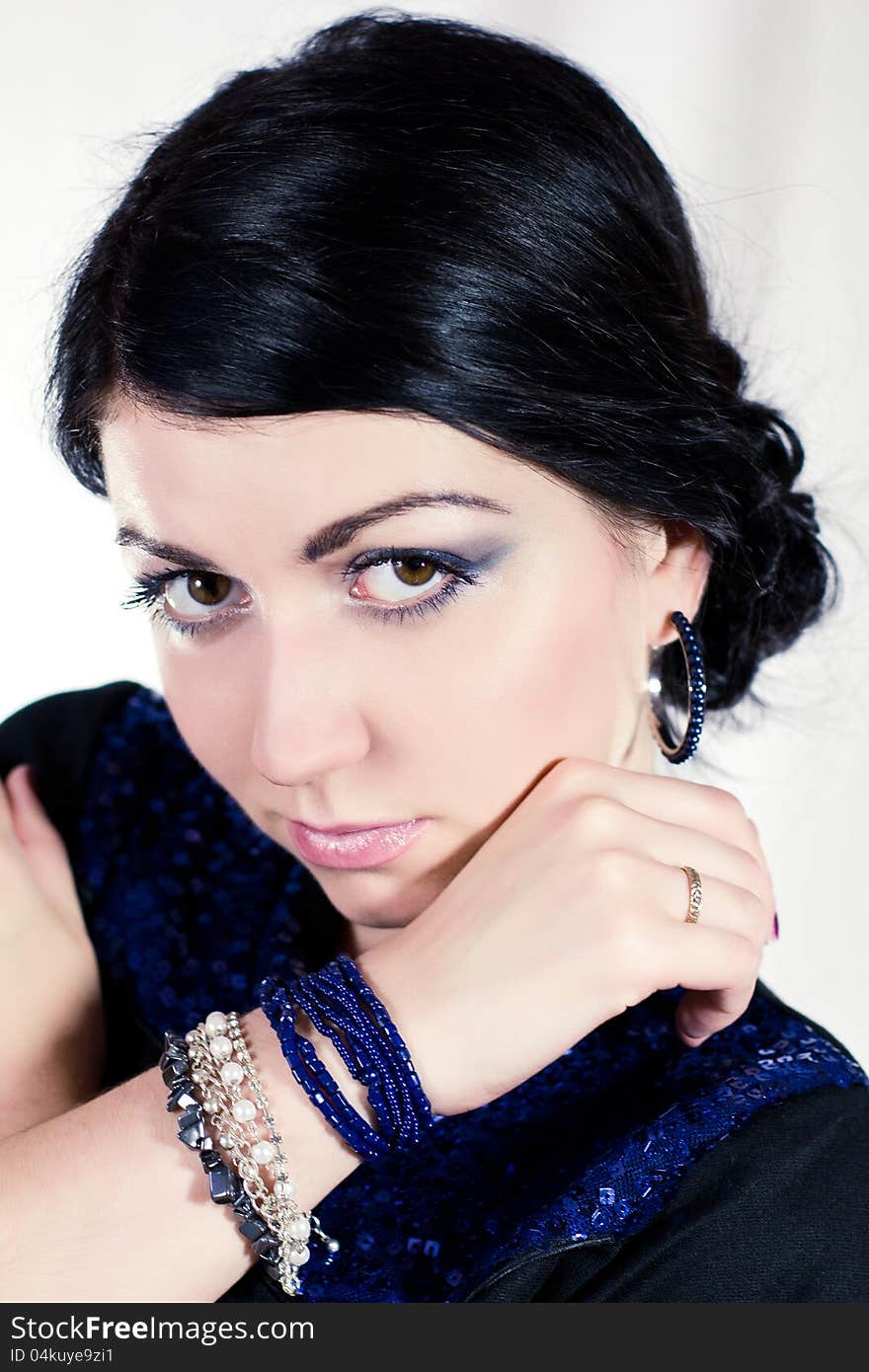 Portrait of beautiful young brunette woman in blue dress and bracelet. Portrait of beautiful young brunette woman in blue dress and bracelet