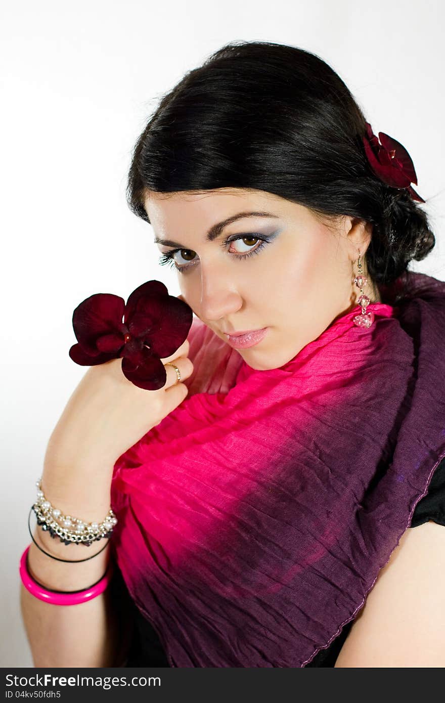 Brunette beauty portrait with orchid, studio shot. Brunette beauty portrait with orchid, studio shot