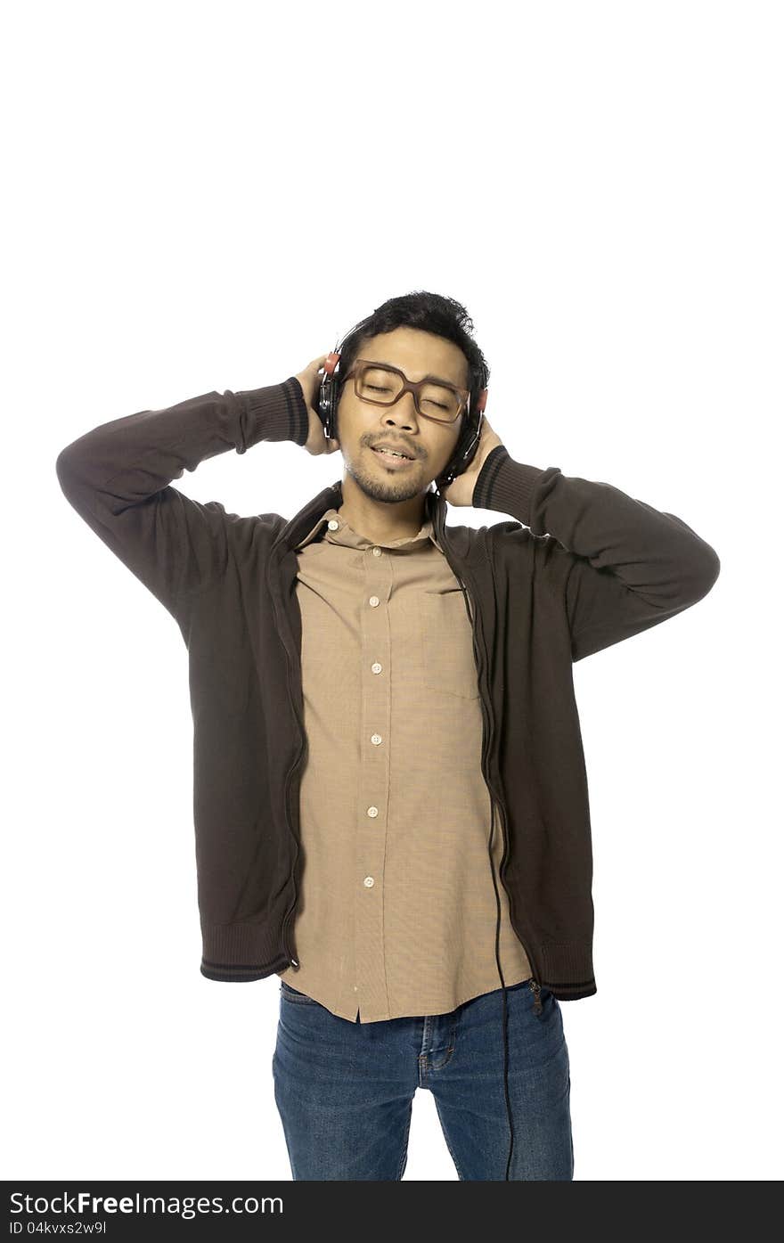 Handsome young man listening to music using headphone. Handsome young man listening to music using headphone