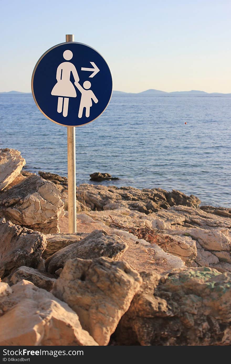 Woman and child walking direction - seaside path traffic sign. Woman and child walking direction - seaside path traffic sign