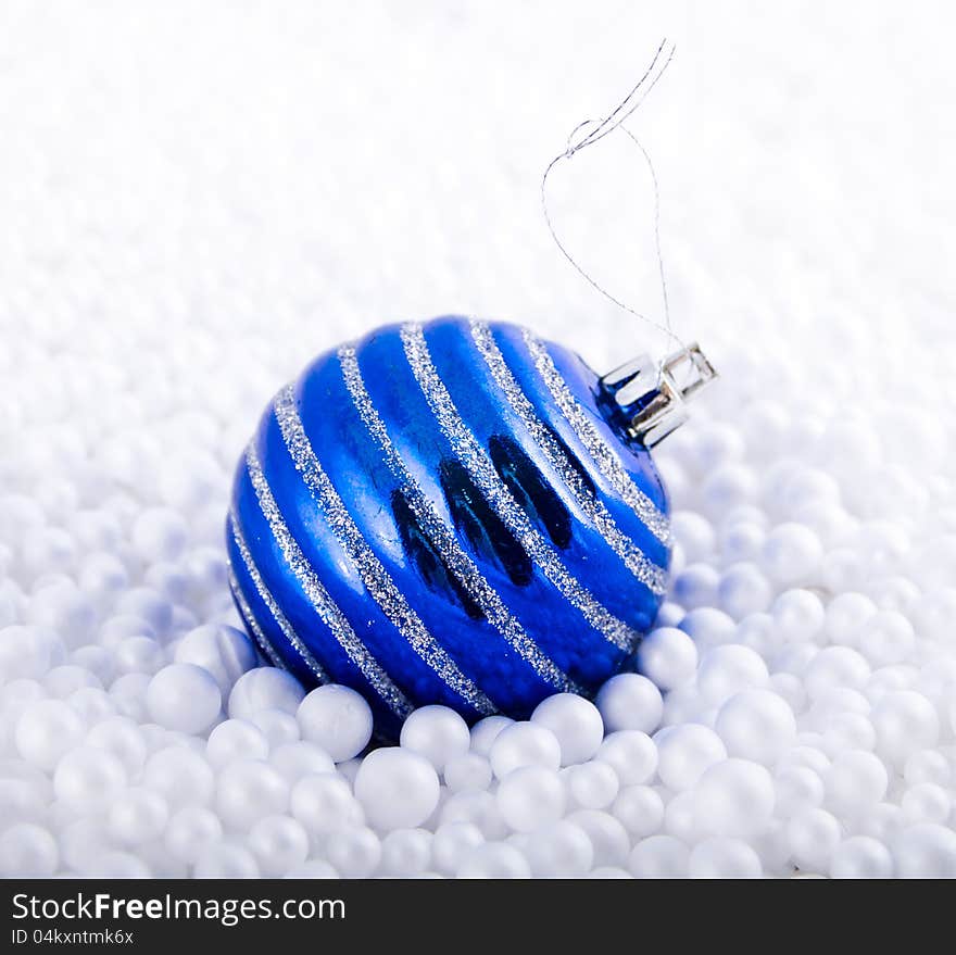 Dark blue fir-tree toy lies in white marbles