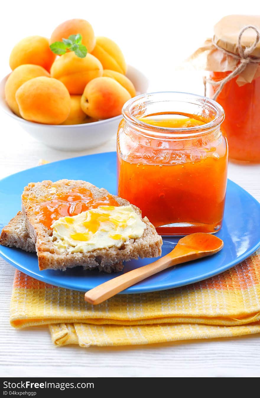 Apricot jam in jar, fresh fruits with bread and butter