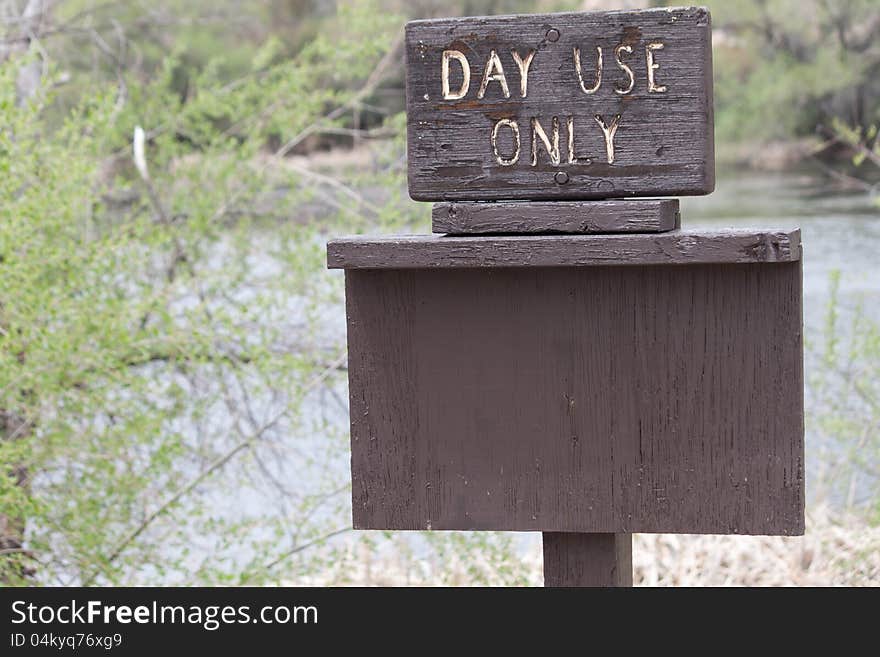 A brown Day Use Only sign with copy space