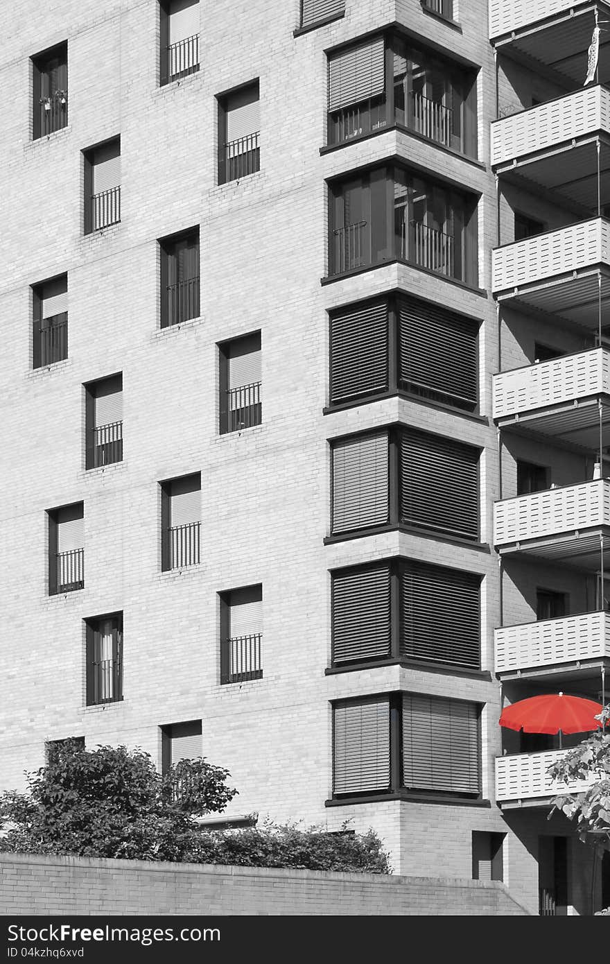 Artistic architectural view in black and white with block of flats with red umbrella