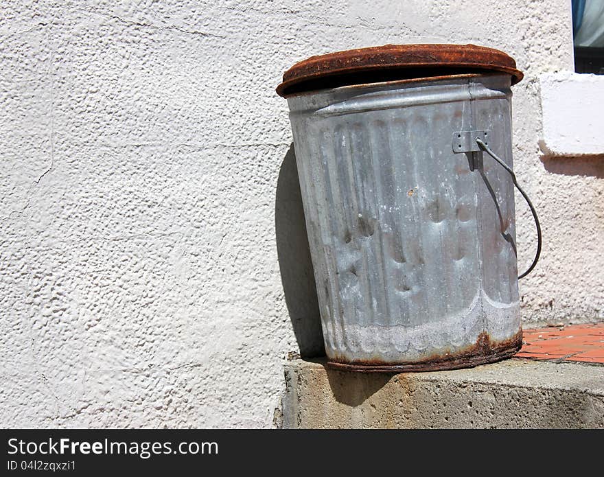 Old rusty metal trash can