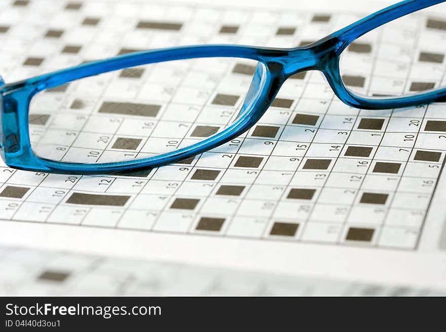 Spectacles on crossword number puzzle background