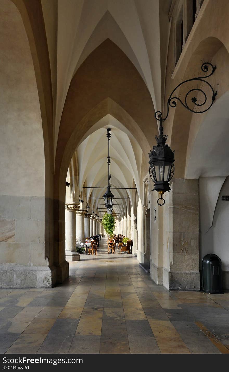 The gothic arcades of Sukiennice (Cloth Hall, Drapers' Hall) on the Main Market Square in Krakow, Poland, with an outdoor cafe. The gothic arcades of Sukiennice (Cloth Hall, Drapers' Hall) on the Main Market Square in Krakow, Poland, with an outdoor cafe