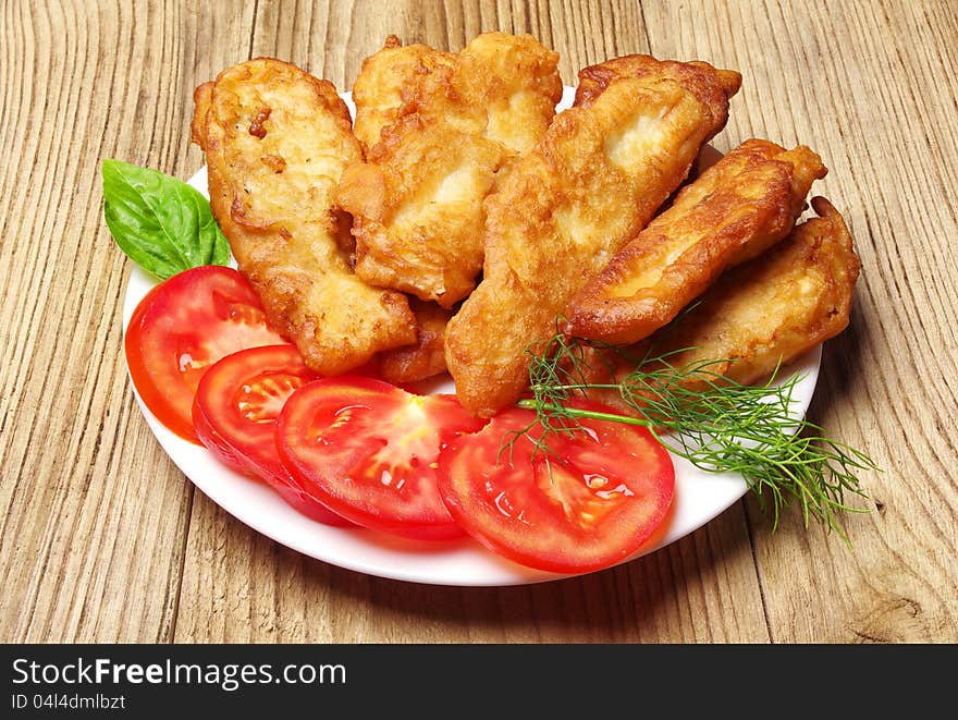 Fish fried in dough on a plate closeup