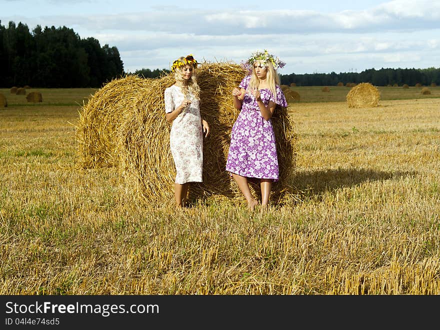 Beautiful girls on the field near the haystacks. Beautiful girls on the field near the haystacks