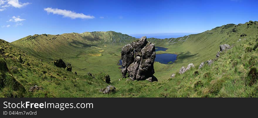 A panoramic view from Caldeirão Lake and the crater of the eruption on the Island of Corvo. In background the Atlantic Ocean. A panoramic view from Caldeirão Lake and the crater of the eruption on the Island of Corvo. In background the Atlantic Ocean.