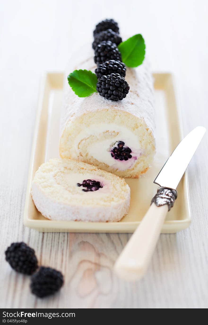 Swiss roll with cream cheese and blackberry, selective focus