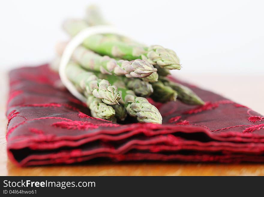 Green asparagus on red napkin. Shallow dof