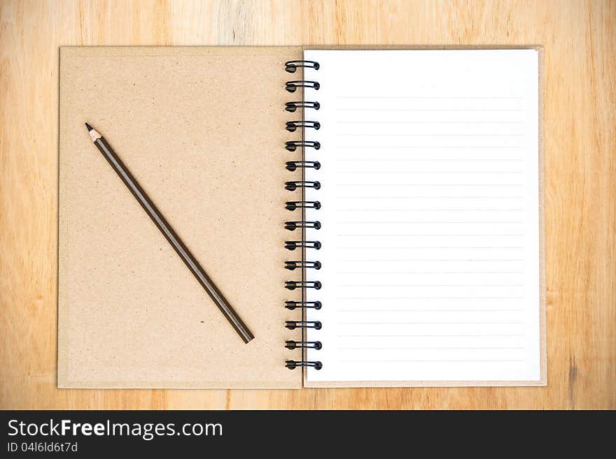 White notebook with frangipani flower on the wood