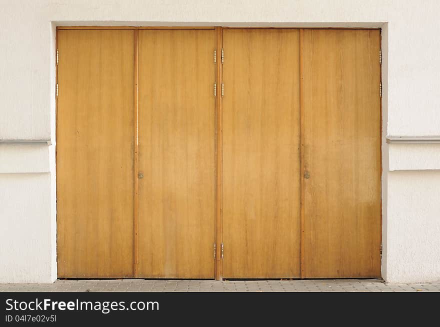 Old closed wooden entrance doors in the exterior of a building. Old closed wooden entrance doors in the exterior of a building